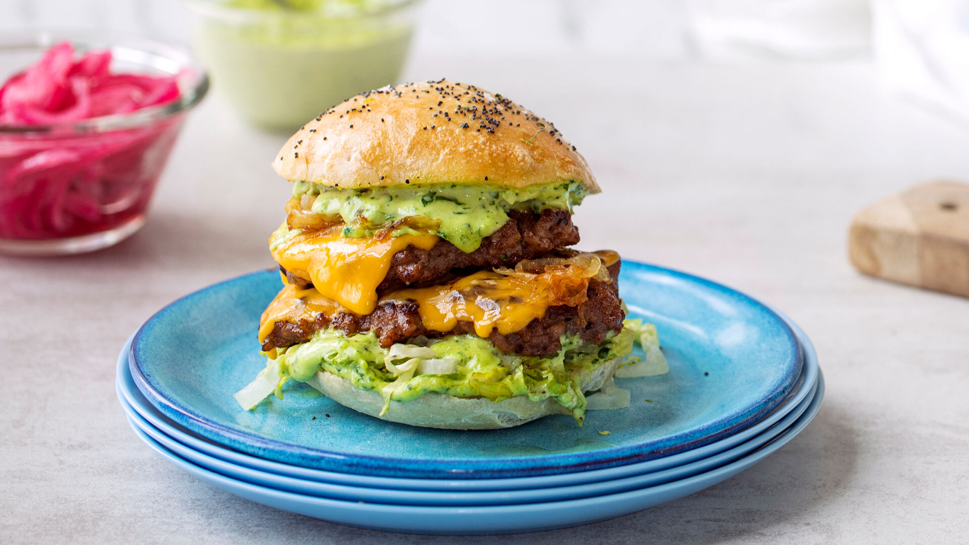 Smashburger av svin og storfe med karamellisert løk, cheddar og urtedressing