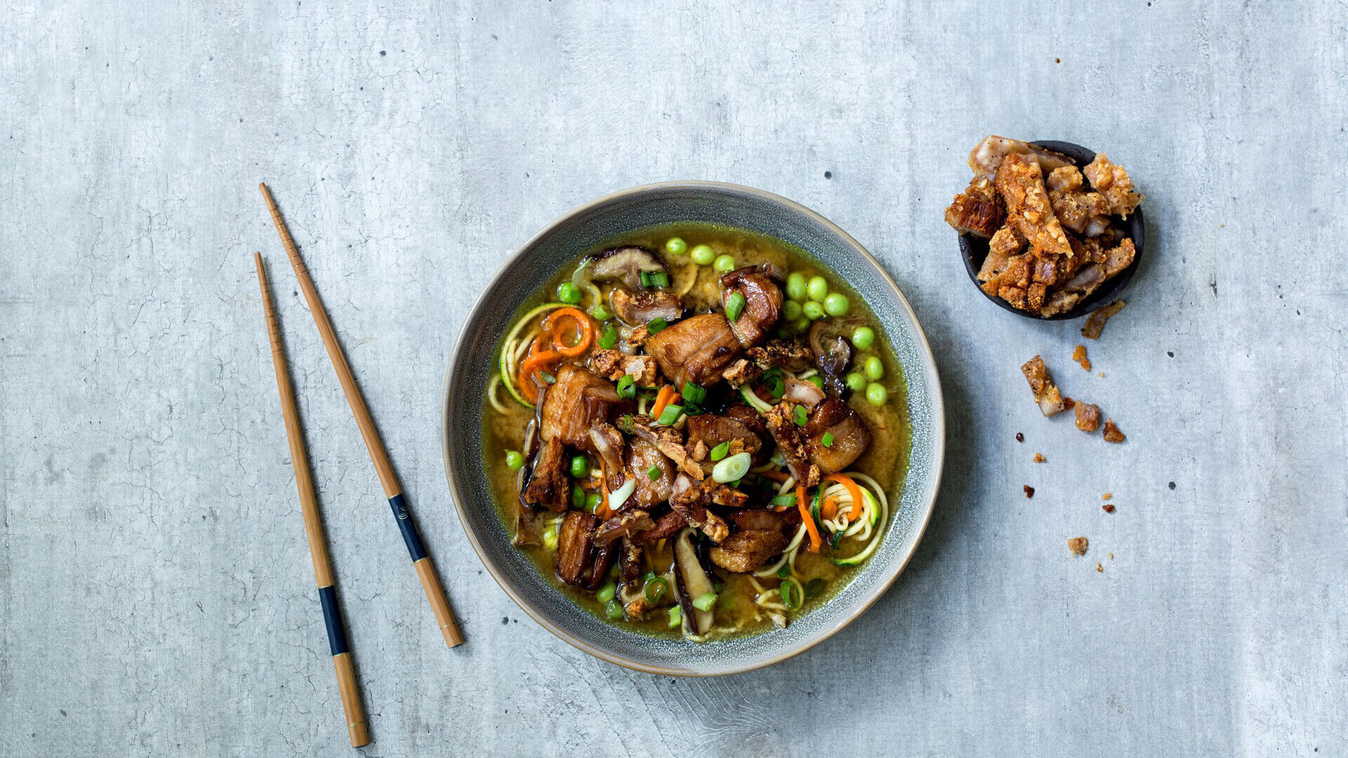 Stykkevis og Delt Miso-suppe med grønnsaksnudler og braisert pork belly strips og sprøstekt svor