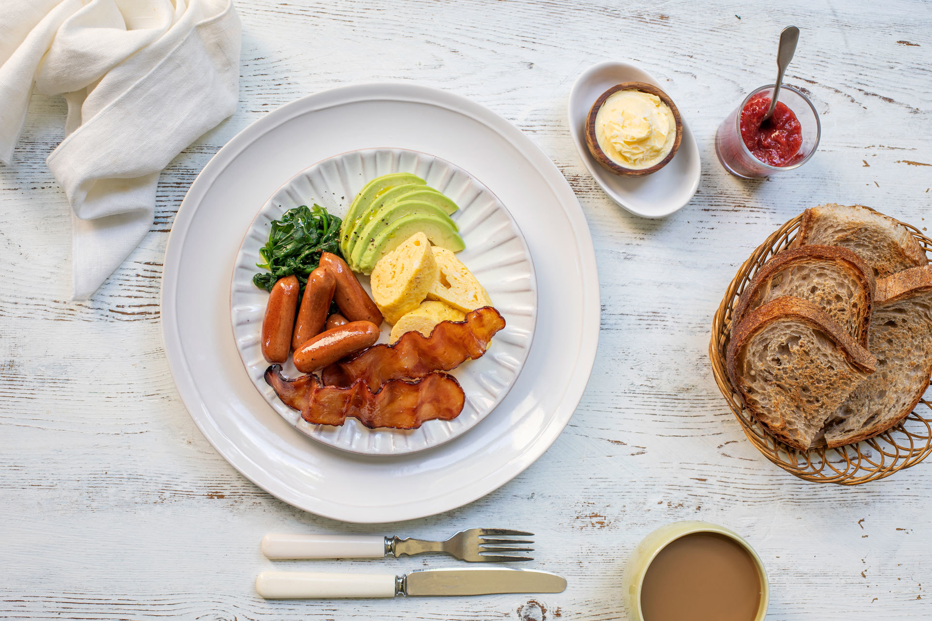 Frokosttallerken med frokostpølser, kalkunbacon og omelett