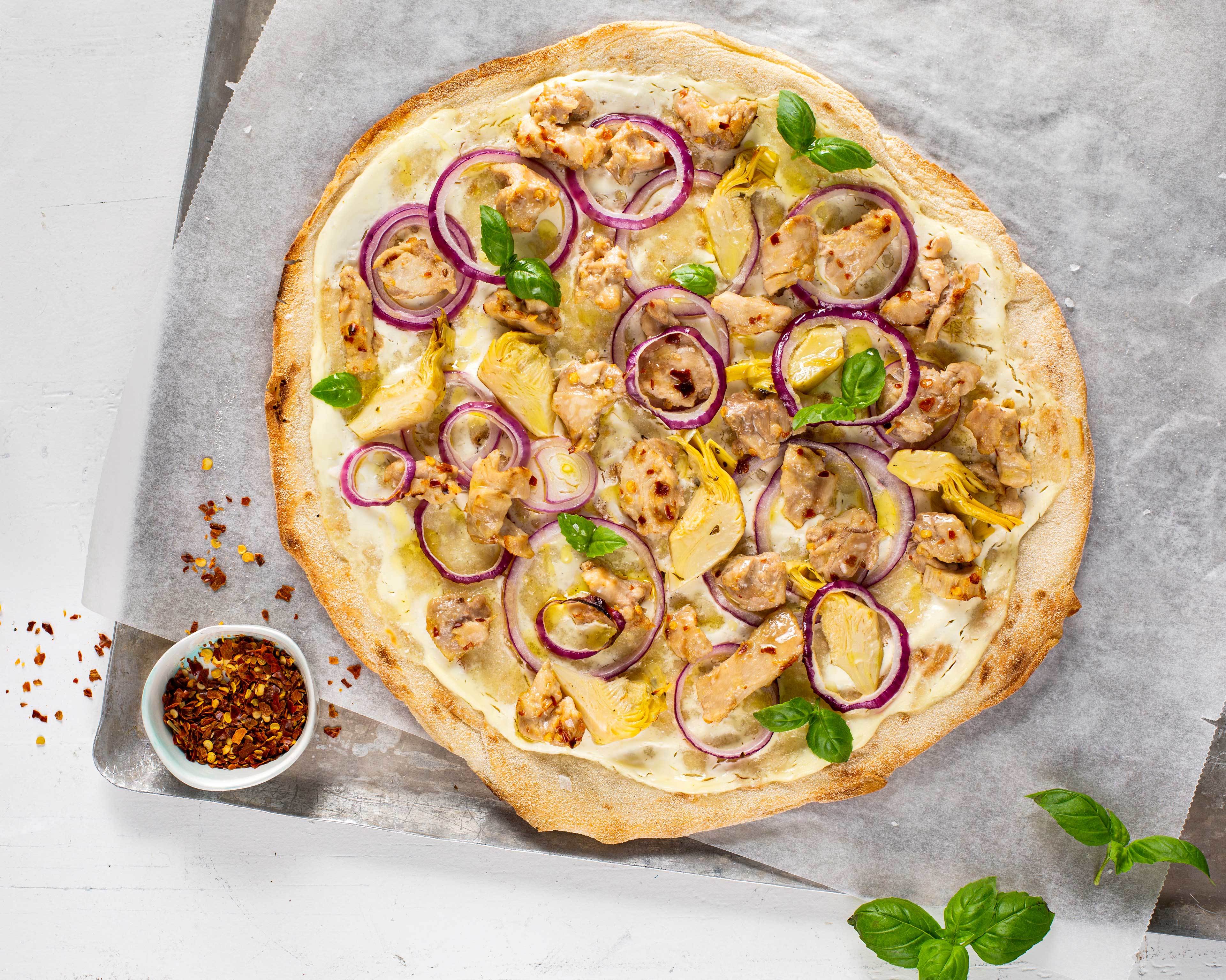 Hvit pizza med kylling, artisjokk, rødløk og basilikum