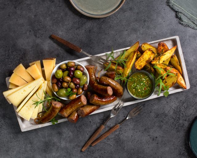 Tapasfjøl: Lammepølse med manchego og oliven, servert med chimichurri, stekte potetbåter, manchego og oliven